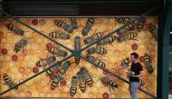U.S. artist Matthew Willey poses by a mural of bees at Pipers Corner School in the south-east English county of Buckinghamshire, part of his Good of the Hive project to hand-paint 50,000 bees on buildings around the world, October 1, 2020. Photo taken Oct