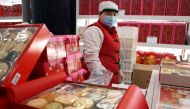 A staff member stands behind Lunar New Year gift sets containing pastries at a food store, following the coronavirus disease (COVID-19) outbreak in Beijing, China February 4, 2021. Reuters/Florence Lo