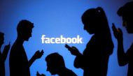 FILE PHOTO: People are silhouetted as they pose with mobile devices in front of a screen projected with a Facebook logo, in this picture illustration October 29, 2014. REUTERS/Dado Ruvic/Illustration/File photo