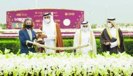 The Amir H H Sheikh Tamim bin Hamad Al Thani presenting a trophy to trainer Julian Smart after Mon’nia won the prestigious Amir Sword at Al Rayyan Park yesterday. 
