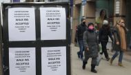 People wearing masks walk past a Shoppers Drug Mart store advertising coronavirus disease (COVID-19) vaccines, in Toronto, Ontario, Canada, March 16, 2021. REUTERS/Chris Helgren
