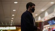 A moviegoer holds a bucket of popcorn at a AMC theatre on reopening day during the outbreak of the coronavirus disease (COVID-19), in Burbank, California, U.S., March 15, 2021. REUTERS/Mario Anzuoni
