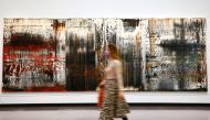 A woman walks past the painting 