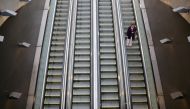 A woman uses mechanic stairs at a metro main access as local town halls have increased the lockdown restrictions during the coronavirus disease (COVID-19) outbreak, in Santiago, Chile, March 25, 2021. REUTERS/Ivan Alvarado