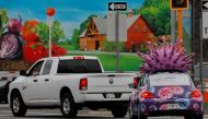 A car, advertising for a company that makes test kits for both the flu and the coronavirus disease (COVID-19) waits at a traffic light with a large model of the influenza virus on its roof, in Medford, Massachusetts, U.S., March 31, 2021. REUTERS/Brian Sn