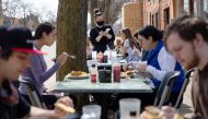People crowd outdoor seating at a restaurant as coronavirus disease (COVID-19) restrictions are eased in Ann Arbor, Michigan, U.S., April 4, 2021. REUTERS/Emily Elconin
