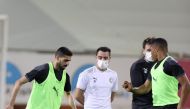 Al Sadd captain Hassan Al Haydos (left) practises with the ball as
Xavi Hernandez (second right) looks on during a training session. 