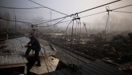 FILE PHOTO: An insurance claims adjuster climbs the entrance to a house in the Breezy Point neighborhood which was left devastated by Hurricane Sandy in the New York borough of Queens November 12, 2012. REUTERS/Adrees Latif/File Photo