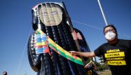 Demonstrators of the social movement Acredito, hold an inflatable doll known as 