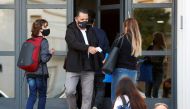 An employee checks the temperature of a woman at the entrance to a school, amid a rise in coronavirus disease (COVID-19) cases , in Buenos Aires, Argentina April 19, 2021. REUTERS/Agustin Marcarian/File Photo/File Photo