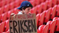 A fan holds a banner of support for Denmark's Christian Eriksen after he collapsed on the pitch during his side's Euro 2020 match with Finland Pool via Reuters/Catherine Ivill