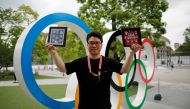 Yoshiyuki Terajima (51), a pin collector based in Tokyo, shows his collection next to the Olympic rings monument in Tokyo, Japan June 13, 2021. Reuters/Issei Kato
 