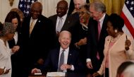 US President Joe Biden laughs with Vice President Kamala Harris and members of Congress as he signs the Juneteenth National Independence Day Act into law as Vice President Kamala Harris stands by in the East Room of the White House in Washington, U.S., Ju