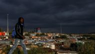 FILE PHOTO: A man walks past an informal settlement as the coronavirus disease (COVID-19) lockdown regulations ease in Soweto, South Africa, April 7, 2021. REUTERS/Siphiwe Sibeko/File Photo
