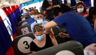 Employees of an assembly factory receive a dose of the Pfizer-BioNTech coronavirus disease (COVID-19) vaccine aboard a bus during a mass vaccination program for people over 40 years of age at a university in Ciudad Juarez, Mexico July 05, 2021. REUTERS/Jo