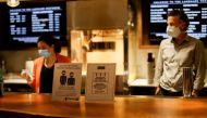 Signs advising about masks and social distancing are pictured by concessions at the Landmark Westwood theatre in Los Angeles, California, U.S., May 14, 2021. REUTERS/Mario Anzuoni/File Photo