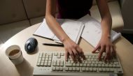 A woman works at her desk typing on a computer in this illustration picture taken January 9, 2005, REUTERS/Catherine Benson//File Photo