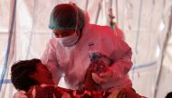 A healthcare worker in personal protective equipment (PPE) treats a patient inside a temporary tent erected outside the emergency ward for accommodating the lack of beds at a government-run hospital amid the surge of coronavirus disease (COVID-19) in Beka