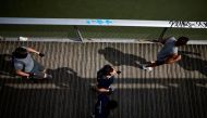 People jog on the Passerelle Simone de Beauvoir, amid the coronavirus disease (COVID-19) outbreak in Paris, France, August 1, 2021. REUTERS/Sarah Meyssonnier

