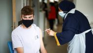A person receives a dose of the Pfizer BioNTech vaccine at the Central Middlesex Hospital in London, Britain, August 1, 2021. REUTERS/Henry Nicholls/File Photo