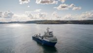 A vessel sails along a coast line as it lays undersea fiber optic communications cable near the village of Teriberka, on the Barents Sea, Russia August 6, 2021. REUTERS/Stringer