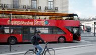 A cyclist rides past an empty tourist bus on the street of Paris, France, March 9, 2020. REUTERS/Pascal Rossignol/File Photo