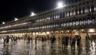 People walk in a flooded St. Mark's Square during an exceptional high water in Venice, Italy August 8, 2021. Picture taken August 8, 2021. REUTERS/Manuel Silvestri