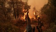 A volunteer reacts as a wildfire burns in the village of Galatsona, on the island of Evia, Greece, August 9, 2021. REUTERS/Stelios Misinas