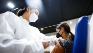 A woman receives a dose of the Moderna vaccine against the coronavirus disease (COVID-19) at the Music Auditorium in Rome, Italy, August 5, 2021. REUTERS/Guglielmo Mangiapane/File Photo