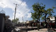 People look at a damaged house after a 7.2 magnitude earthquake in Les Cayes, Haiti August 15, 2021. REUTERS/Estailove St-Val