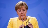 German Chancellor Angela Merkel holds a protective mask during a news conference on the current developments in Afghanistan, at the Chancellery in Berlin, Germany August 16, 2021 Odd Andersen/REUTERS