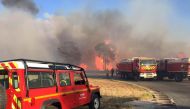 Firefighters work near a major wildfire that broke out in the Var region of southern France, August 17, 2021 SDMIS69/Handout via REUTERS
