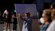 Spanish artist Antonio Lopez checks the perspectives during one of his sessions to paint the famous Puerta del Sol square in Madrid, Spain, August 4, 2021. Picture taken August 4, 2021. REUTERS/Juan Medina