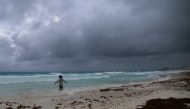 A tourist stands on a beach as Hurricane Grace approaches, in Cancun, Mexico, August 18, 2021. REUTERS/Paola Chiomante NO RESALES. NO ARCHIVES
