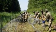 Lithuanian army soldiers install razor wire along the border with Belarus, in Druskininkai, Lithuania, July 9, 2021. Reuters/Janis Laizans/File Photo