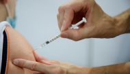 A medical worker administers a dose of the Pfizer-BioNTech 