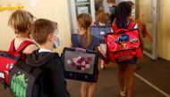 Schoolchildren, wearing protective face masks, gather as they arrive at a primary school on the first day of the new school year after summer break, in Vertou, France, September 2, 2021. REUTERS/Stephane Mahe