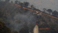 A helicopter makes a water drop over a wildfire on Sierra Bermeja mountain in Estepona, Spain, September 9, 2021. REUTERS/Jon Nazca