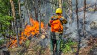 Specialists work to extinguish a wildfire in the region of Yakutia, Russia, in this handout picture released August 17, 2021. Aerial Forest Protection Service/Handout via REUTERS