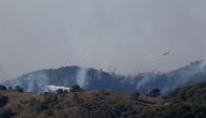 Firefighting planes are seen flying from Parauta as they make a water drop over a wildfire on Sierra Bermeja mountain, in Estepona, Spain, September 10, 2021. REUTERS/Jon Nazca
