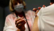 A medical worker administers a dose of the 