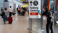 A worker sanitises a sign at the International arrivals area of Terminal 5 in London's Heathrow Airport, Britain, August 2, 2021. REUTERS/Peter Nicholls/Files

