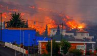 Lava flows behind houses following the eruption of a volcano in the Cumbre Vieja national park at Los Llanos de Aridane, on the Canary Island of La Palma, September 20, 2021. REUTERS/Borja Suarez