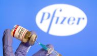 FILE PHOTO: FILE PHOTO: A woman holds a small bottle labeled with a 