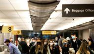Travelers wearing protective face masks to prevent the spread of the coronavirus disease (COVID-19) reclaim their luggage at the airport in Denver, Colorado, U.S., November 24, 2020. REUTERS/Kevin Mohatt/File Photo/File Photo