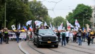 People take part in a protest on the day the Dutch authorities introduce a mandatory 