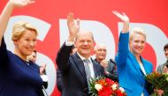 Social Democratic Party (SPD) leader and top candidate for chancellor Olaf Scholz, Mecklenburg-Western Pomerania state Prime Minister Manuela Schwesig and SPD member Franziska Giffey wave as they carry bouquets of flowers at their party leadership meeting