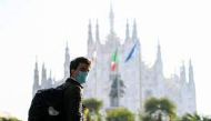 A man wearing a mask walks in the Duomo square as Lombardy tightens restrictions due to a surge in the number of the coronavirus disease (COVID-19) infections in the region, in Milan, Italy, March 5, 2021. REUTERS/Flavio Lo Scalzo/File Photo