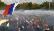 Protesters get hit by a water cannon during a protest against the coronavirus disease (COVID-19) restrictions from the government, in Ljubljana, Slovenia, September 29, 2021. REUTERS/Borut Zivulovic
