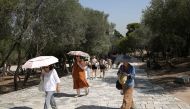 People without protective face masks make their way at an archaeological site of the Acropolis following the easing of measures against the spread of the coronavirus disease (COVID-19) in Athens, Greece, June 24, 2021. REUTERS/Costas Baltas

